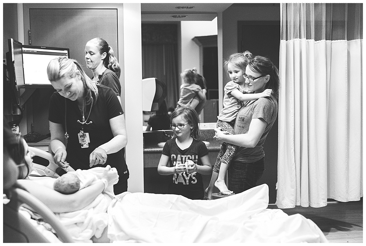 Family members gather around new mom in delivery room