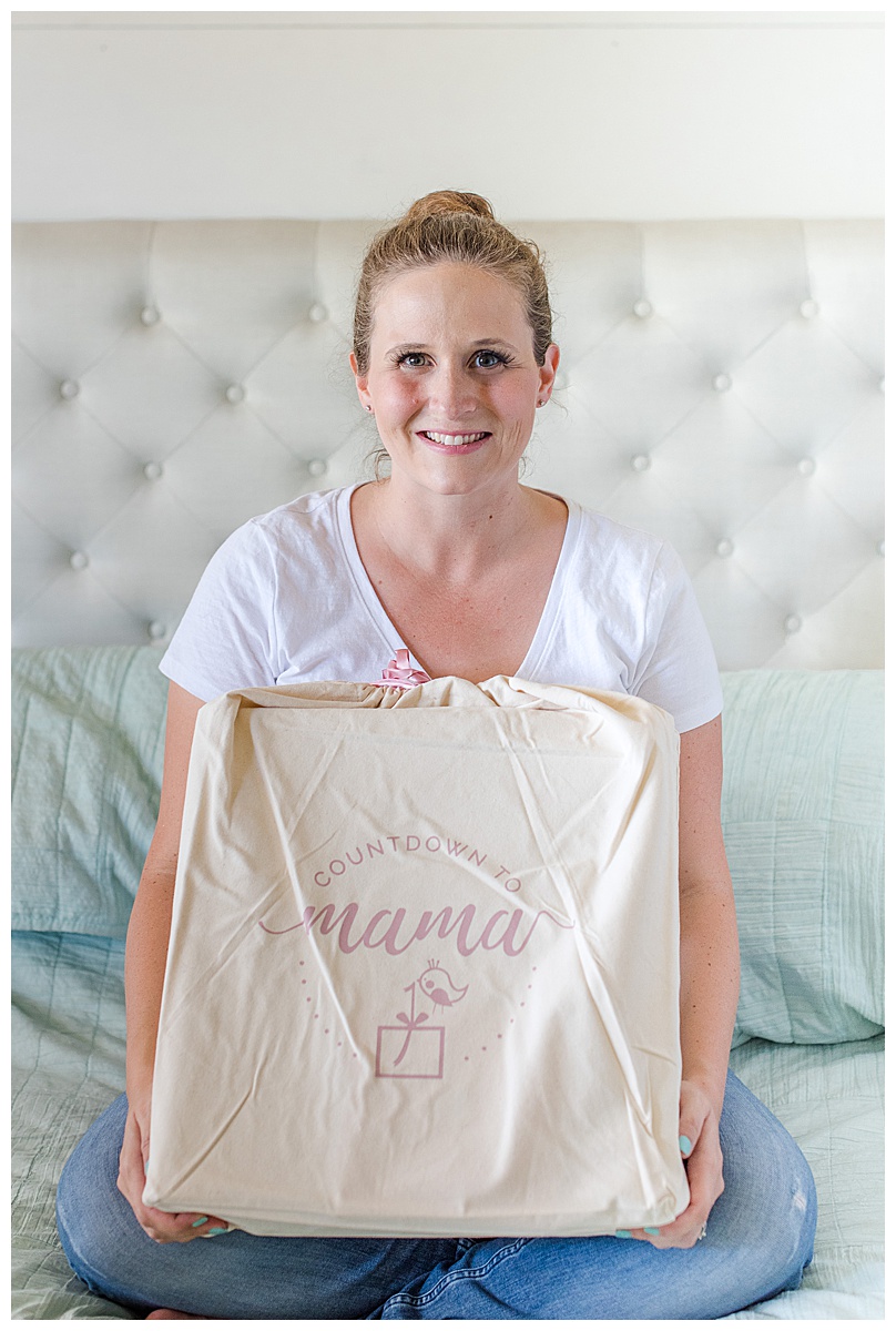 Mom to be holding her newly gifted Countdown to Mama advent calendar