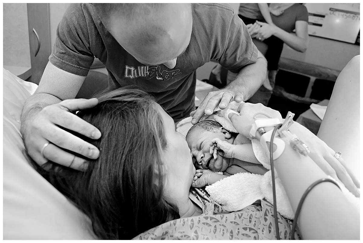 black and white image of mom and dad looking at newborn baby boy in Scottsdale Shea hospital delivery room