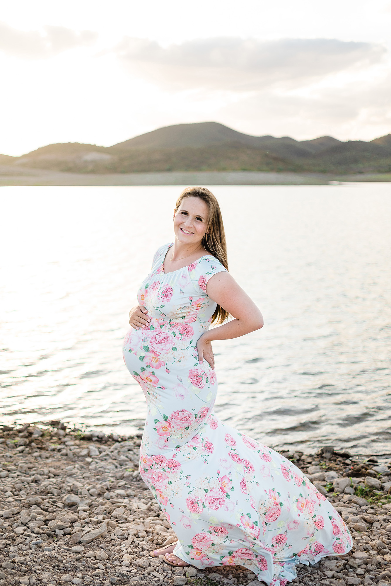 36 week pregnant woman wearing a blue floral dress for her lakeside maternity photo session